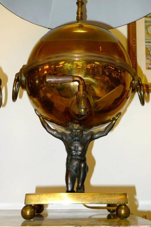 An impressive table lamp conversion of a 19th century brass & copper samovar urn in the Regency style with delicately cast figure of Atlas holding the globe.  Supported on square solid brass platform with four brass ball feet.