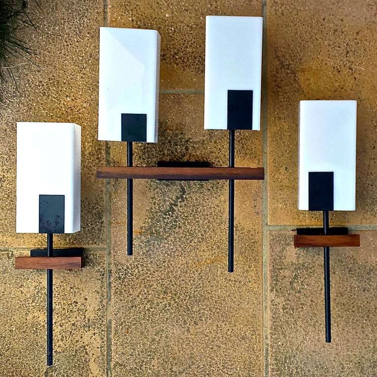 Series of three French 1950's sconces in black lacquered steel, rosewood and white perspex diffusors with steel embellishments.   Two single sconces and one double sconces.  Hefty and masculine.