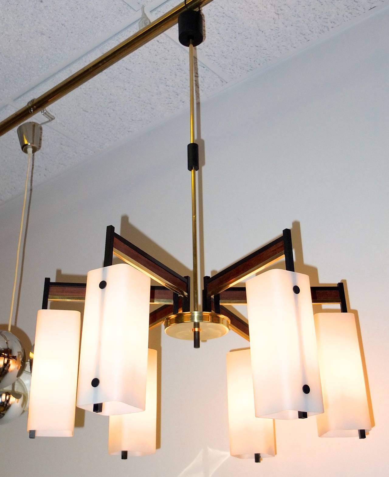 1950's Italian chandelier attributed to Stilnovo with six arms with suspended opaline glass box shades.  Brass, black enameled brass and walnut. Completely restored.  Height adjustable. Up to 75 watts per  socket for 450 watts total.

Dimensions: