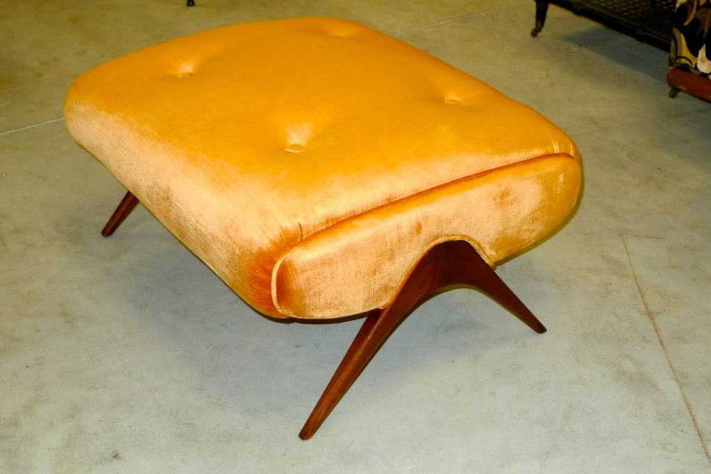 This foot stool is an early homage to Vladimir Kagan's ottoman which was the companion to his wing-back lounge chair for Dreyfus. Solid walnut boomerang form legs. Newly upholstered in shimmering apricot velvet.