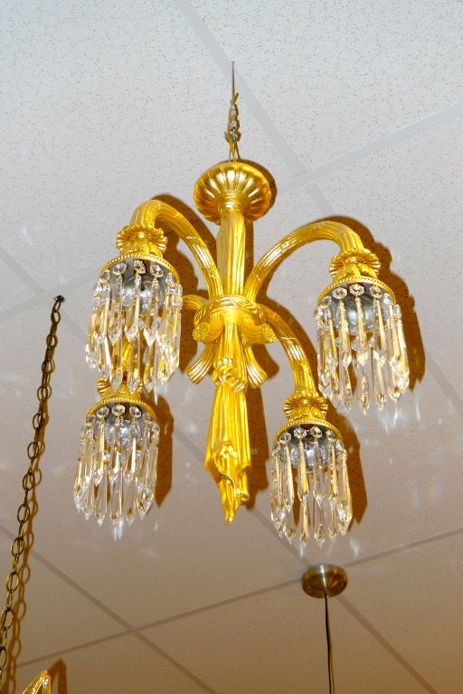 

Elegante lampadario francese a quattro bracci in bronzo dorato con pendenti in cristallo tagliato.