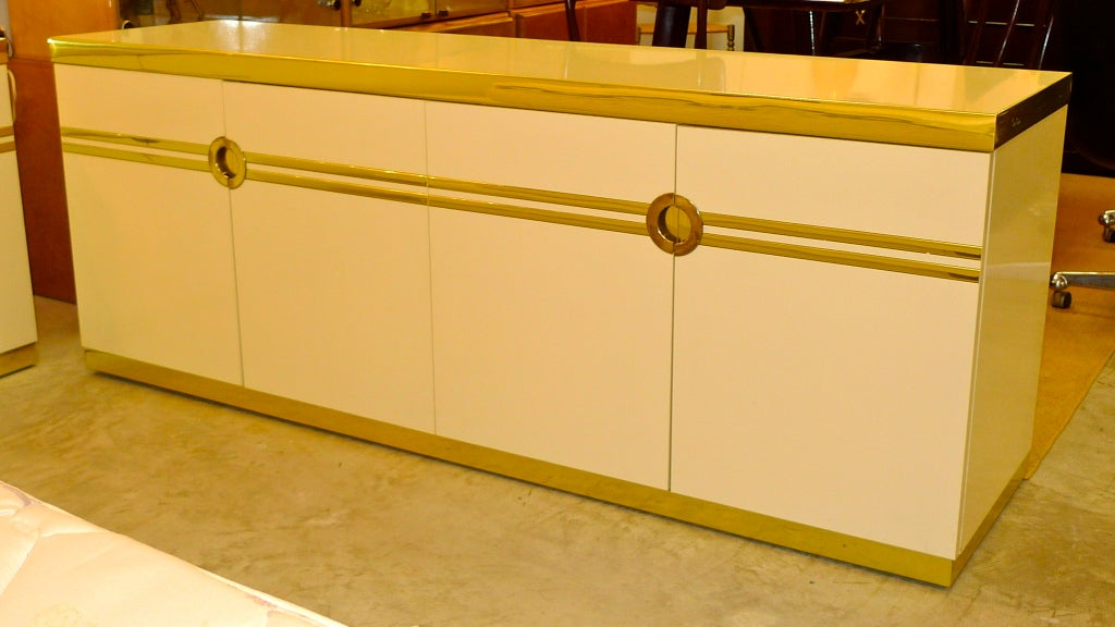 Unbelievable clean and glam long low dresser by Pierre Cardin for Dillingham in high gloss ivory laminate and polished brass trim.