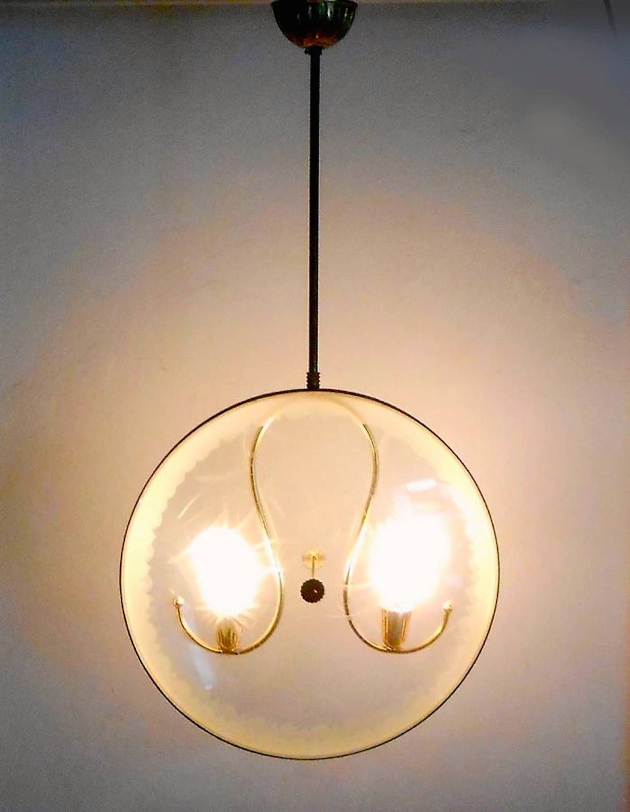 Forma muy inusual. Este colgante, que suele presentarse horizontalmente como un platillo volante con el vástago atravesando el eje central del OVNI, tiene forma de reloj de bolsillo, con lentes de cristal grabado a ambos lados dentro de un marco de