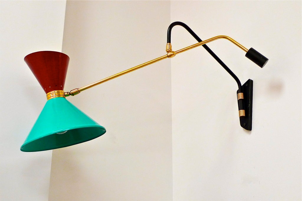 Joyful and intricately constructed wall mounted balancing swing arm lamp by Pierre Guariche with tu-tone diabolo shade in enameled aluminum. Rewired and sockets changed to accept screw cap bulbs (full size in bottom, candelabra bulb in top cone.