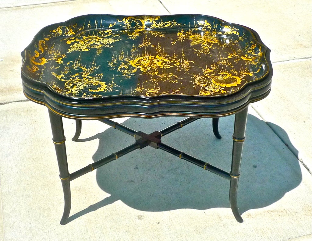 Papier-mache scalloped edge tray insert on an ebonized and parcel gilt faux bamboo stand. The tray is decorated in a Chinoiserie floral motif.