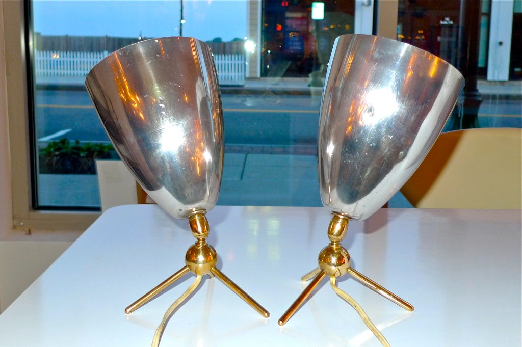 Fine example of 1950's French whimsical lighting design from the house of Disderot.  Probably designed by Jacques Biny or Boris LaCroix. Handsome brass tripod base with bulbous swivel joint and an nearly cannon shell sized aluminum cone for the