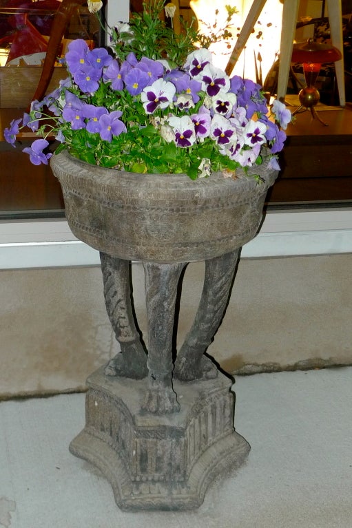 Exquisite sandstone planters of 18th century Italianate tri-pod form with hairy paw feet on a raised neoclassical triangular plinth with triglyphs and metopes.  Round bowl with egg and dart detail and Medusa head ornamentation.  Each planter is in