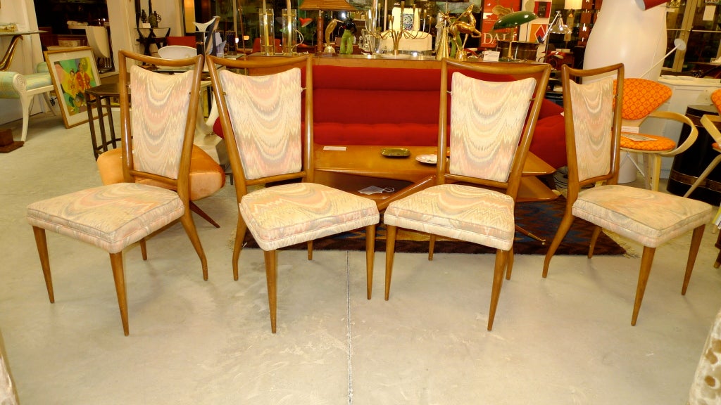 Set of FOUR late 1950's John Widdicomb modernist dining chairs in walnut with upholstered seat and floating back cushions held suspended by brass fittings.  Designed by J. Stuart Clingman.  The sinewy lines, tapered legs and floating back panel are