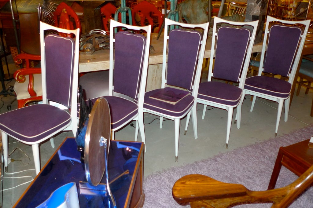 Set of six French dining chairs from the late 1940's/early 1950's with modernist open floating back rest.  White lacquered solid wood and steel sabots.  Newly upholstered in purple micro suede with contrasting white piping.