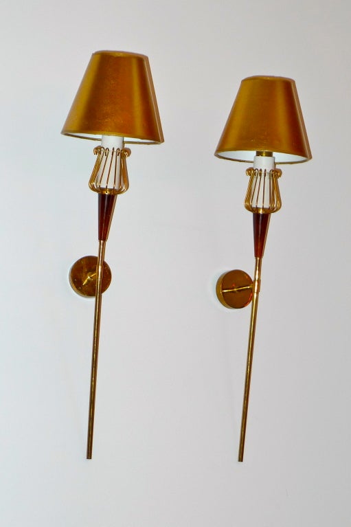 Slim and elegant wall appliques in torchiere form with brass round back plate, long brass stem, enameled brass cone and brass wire socket cup holder in form of a thistle.  Shades are for display only.  The shades you choose will have an enormous