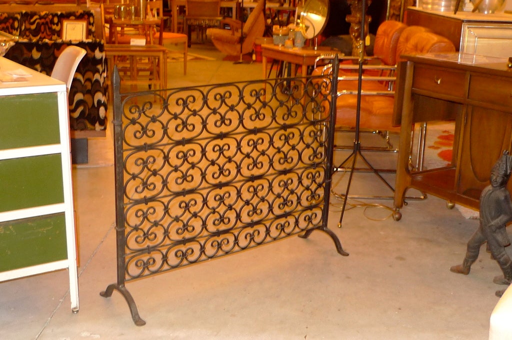 A standing single pane wrought iron fireplace screen.  In the manner of Oscar Bach.