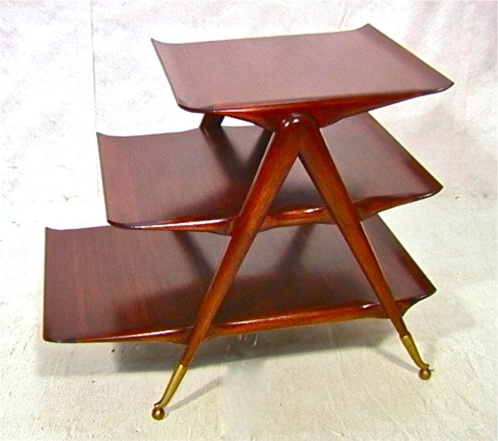 Dramatic three tier magazine stand or side table attributed to Ico Parisi expertly constructed from polished rich walnut with progressively sized tiers of table tops each with up-swept ends, supported by inverted 