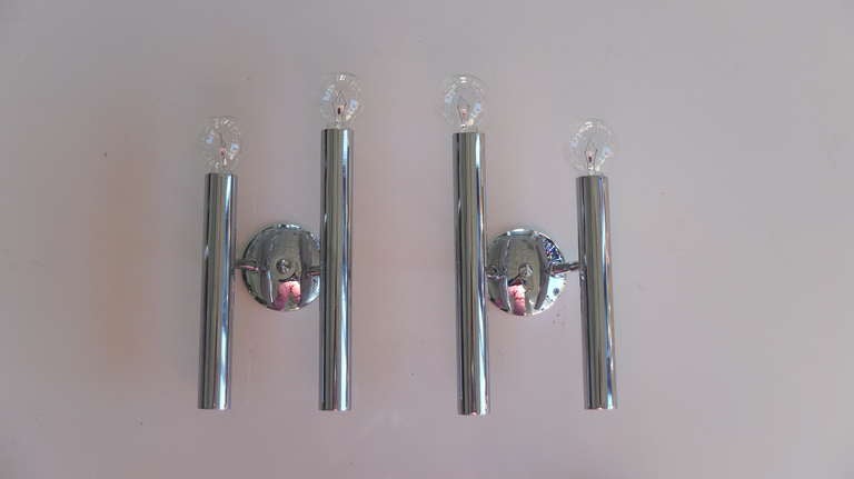 Pair of chrome double tube Italian sconces in the style of Gio Ponti and Gaetano Sciolari. Tubes are of asymmetric height. One candelabra size 60watt bulb per tube.  Excellent condition.