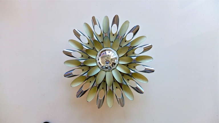 This is a very unusual flushmount ceiling or wall fixture found in Italy but probably from the Netherlands.  Made from Cannoll-shaped tubes of polished aluminum which have been fanned out and riveted in circular formation around a central bulb