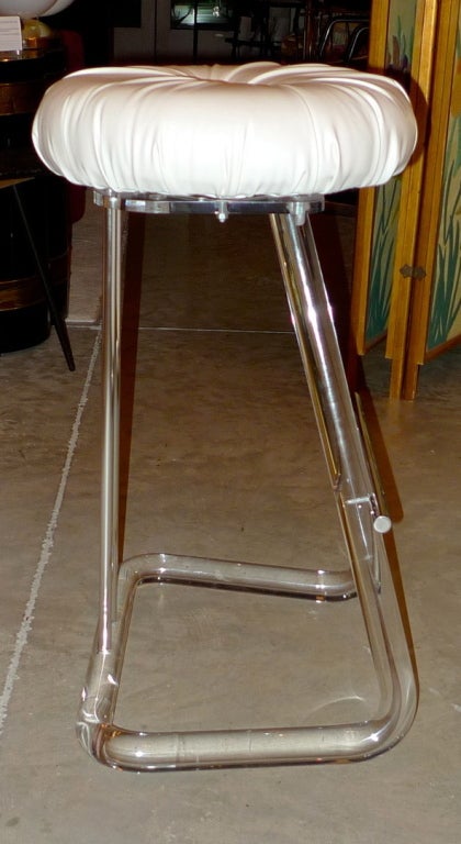 Set of four absolutely pristine stools in thick Lucite rod and chrome with swivel seats upholstered in pearlescent white faux leather with a satin finish