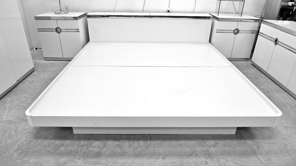 Beautiful 1970's French glam platform bed in white laminate and chromed aluminum designed by Pierre Cardin.

See our separate listing for the matching pair of nightstands/small bedside cabinets as well as a bedroom suite in white with brass finish.