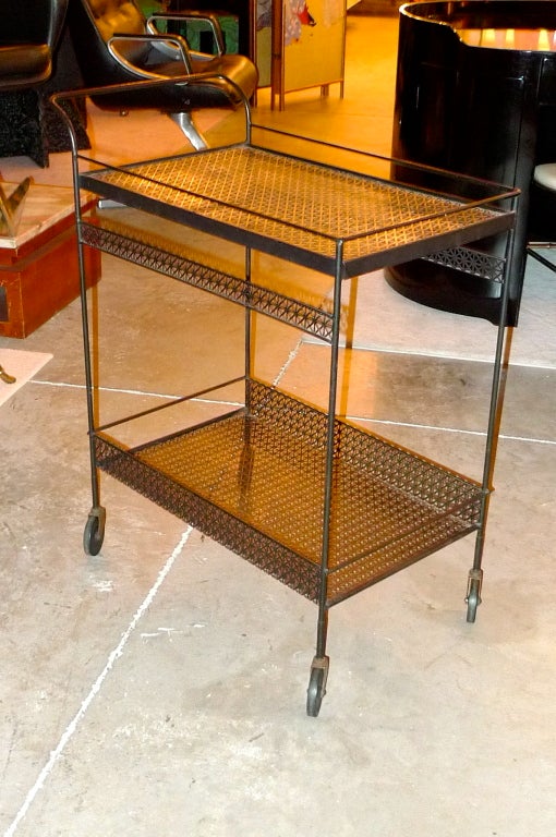 Wonderful bar cart or serving trolly in the style of Mathieu Mategot.  Black enameled perforated metal