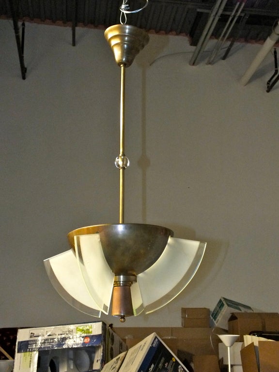 Superbe pendentif/chandelier art déco français en forme de coupe en bronze avec un fleuron en cuivre et quatre panneaux de verre incurvés qui sont éclairés de l'intérieur de la coupel....deux ampoules.  Attribué à Jean Perzel.

Le diamètre du bol