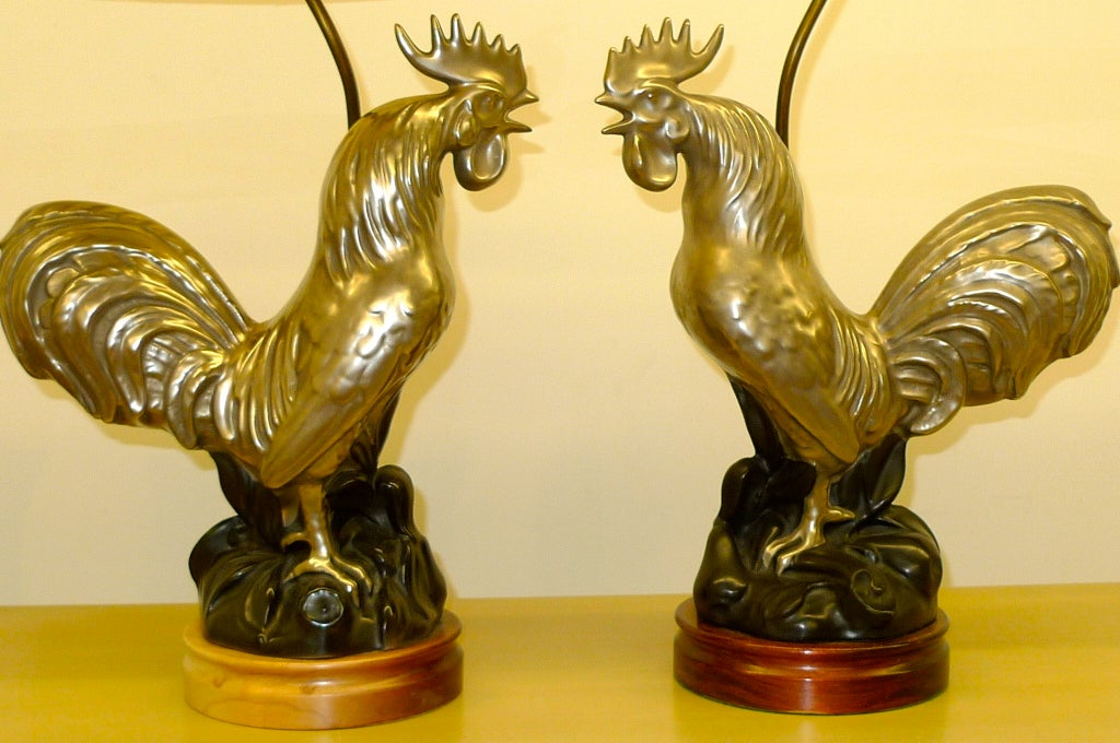 Magnificent pair of silver glazed ceramic lamps in the form of two roosters who look like they're about to get into an argument.

The roosters themselves are 17” high x 15” long. 

With the base they’re 19” high to the top of the rooster, not