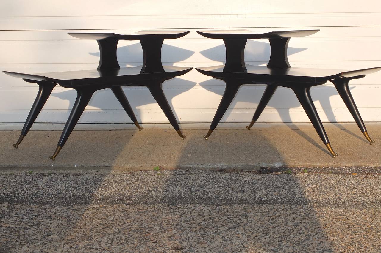 Sculptural and sleek 1950's Italian style  two-tier side tables with upswept blade-edges, spread-eagle tapered compass legs capped with solid brass double-ball feet. 
These tables are frequently mis-attributed to Gio Ponti and Ico Parisi.
Designed