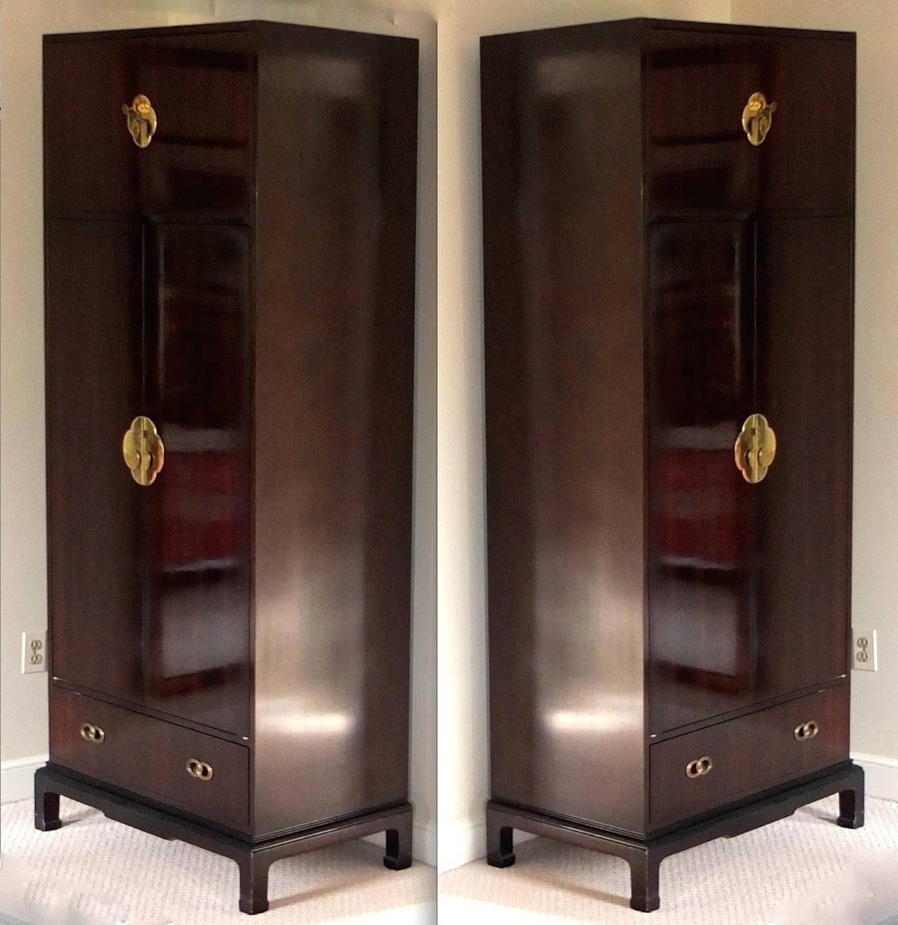 Pair of Ming style double door wardrobe chests by Henredon, circa 1982.

Finish is a dark mahogany with reddish undertones.  In normal light these appear quite dark brown with a highly polished finish. See images 5 - 9 which were taken outside in