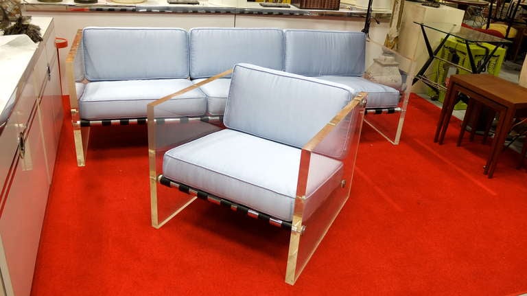 Ultra chic and uber quality lounge chair by Milo Baughman built with three industrial polished aluminum poles with stainless steel end caps, belted with black leather straps and ended with 1-1/2 inch thick slabs of clear Lucite.  Cushions newly made
