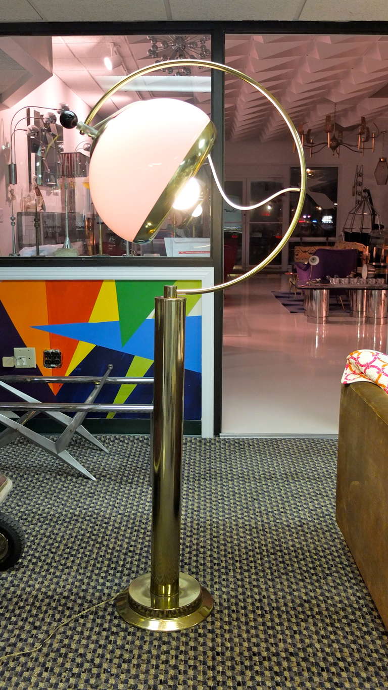 This is an imposing floor lamp, occupying volume while at the same time both appearing and shedding light. The large white acrylic dome can be moved and fixed in any position on the 130 degree arc....even have its direction faced towards any point