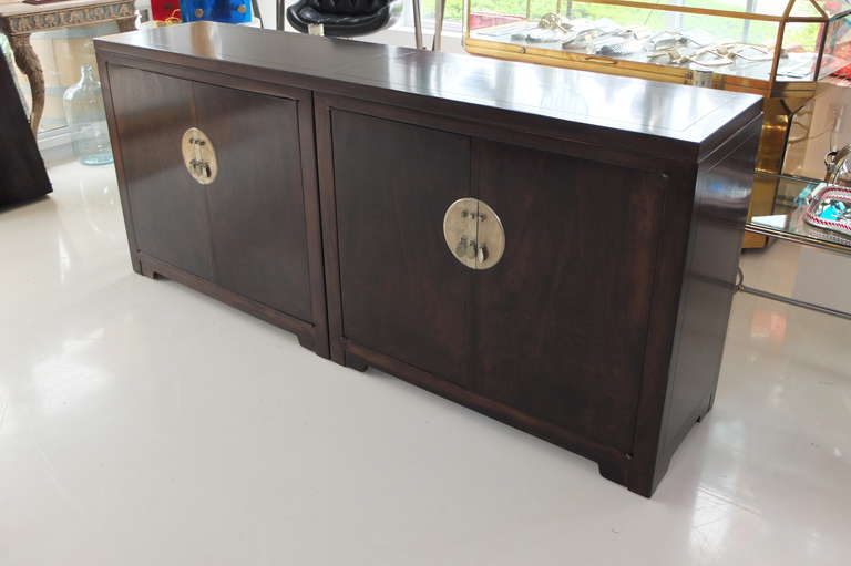 Designed in 1948 for Baker's Far East Collection this elegant sideboard is actually a pair of two door cabinets mounted with a single top. Signature nickel hardware.  Doors open to to reveal an open cabinet to the right and two drawers and open