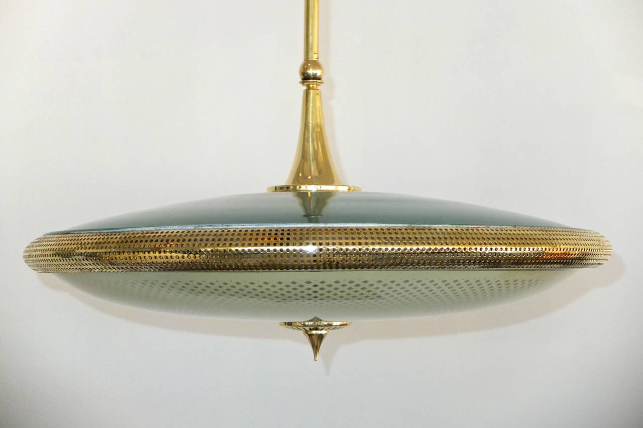 UFO pendant with a difference: light emitted downwards and out from the perforated brass band. There's a surprising amount of heft to this early 1950's Italian flying saucer form pendant with green enameled aluminum top saucer, latticino glass for