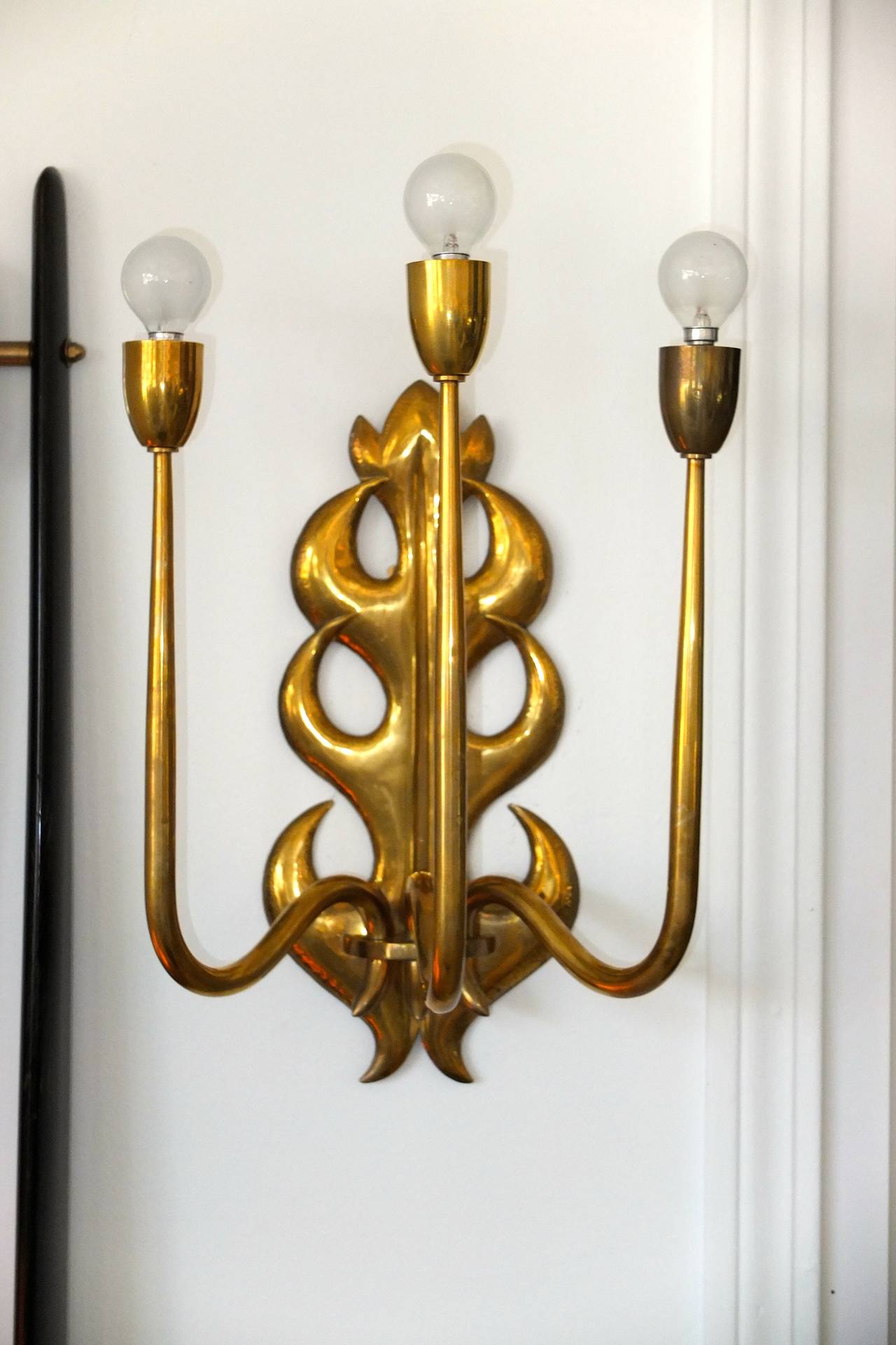 A single 1950s Italian brass three arm wall lamp in the manner of Gio Ponti and Tomaso Buzzi.

Three E12 candelabra sockets 60 watts each.

Rewired.