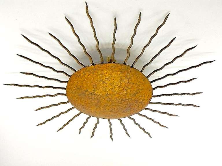 A sunburst design ceiling light fixture, bronze patinated finish on hand hammered metal.  Within the bowl are two sockets for candelabra size bulbs.  Rewired.