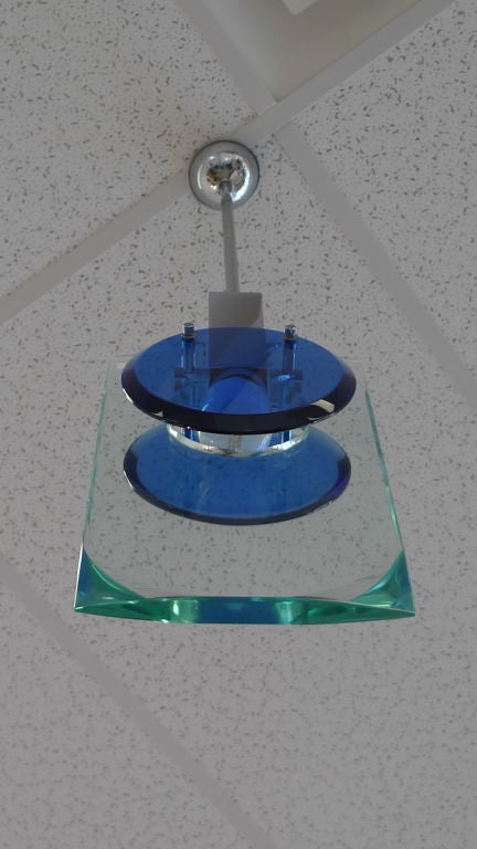 Bold cobalt blue thick cut glass disks flank a molded rectangular clear crystal slab of glass by Cristal Art, Torino, 1960. Holds a single Edison screw bulb in chromium fitting suspended from chrome drop rod.
Hangs 33 1/2 inches. Chrome rod can be