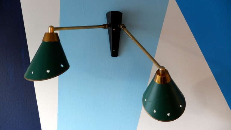 French 1950's wall lamp in the style of Jacques Biny with two independently articulating arms with multi-directional swivel joint at the base of each arm. Each arm extends 10 inches from the base to the center of the cone.

Shades are the original