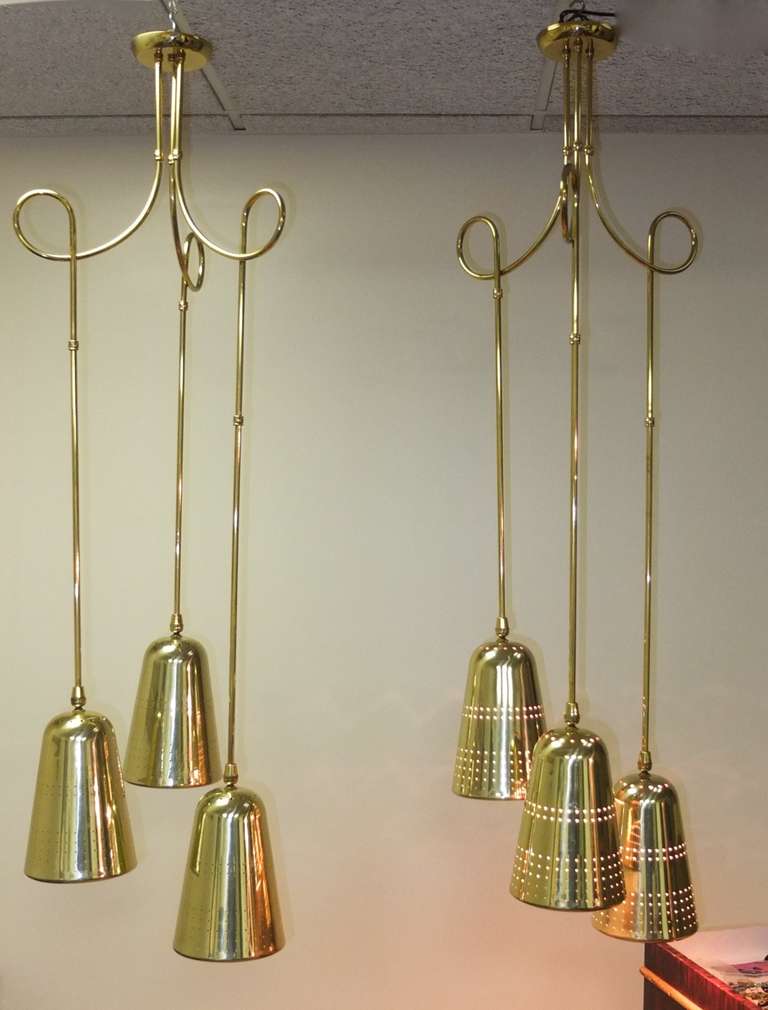 Pair of suspension light fixtures consisting of three perforated brass cones by John C. Virden Lighting Company circa 1955 in the style of Paavo Tynell.  The brass tubing is in sections so can be adjusted and customized .  Even the scrolling loops