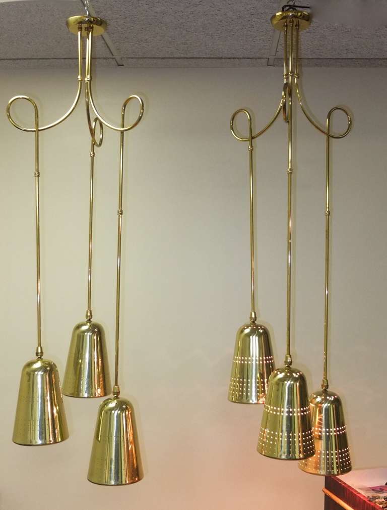 Pair of suspension light fixtures consisting of three perforated brass cones by John C. Virden Lighting Company circa 1955 in the style of Paavo Tynell.  The brass tubing is in sections so can be adjusted and customized .  Even the scrolling loops