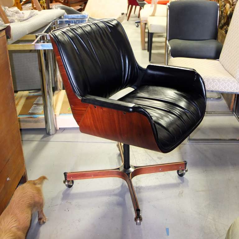 This is a rare edition from a limited production Plycraft produced of George Mulhauser's design for the Mr. Chair series.

Two piece molded plywood chair construction upholstered in black faux leather.

Four star walnut base on castors.