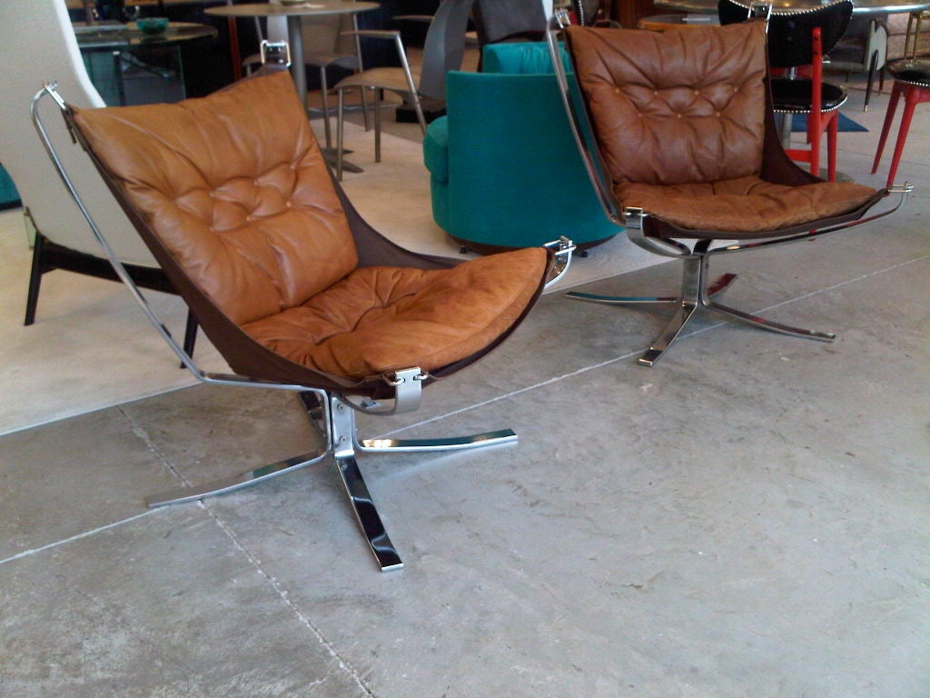 This is a gorgeous pair of Falcon Chairs by Sigurd Ressel produced in 1973 in polished flat-bar chromed steel, medium brown leather and brown canvas sling.