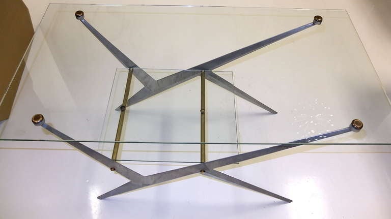 French modernist coffee table with two tiers of tempered glass supported by geometrically asymmetric cast aluminum frames with brass fittings.

Previously enameled flat black we have chosen to present this piece in unfinished brushed aluminum.