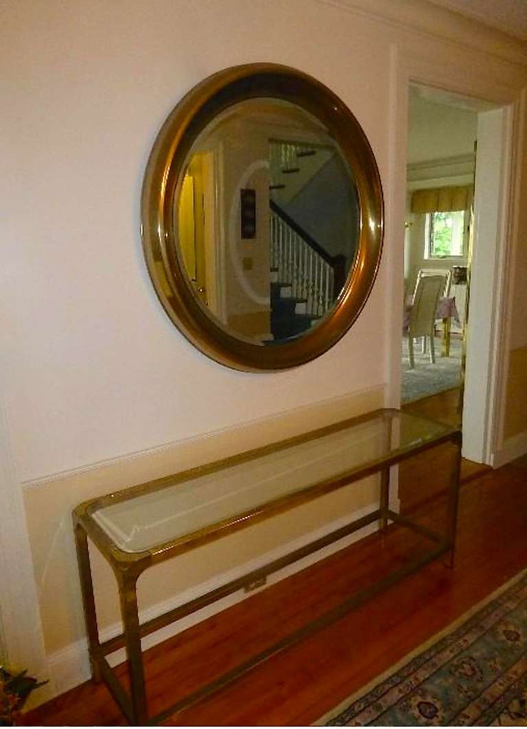 Solid brass console table by Mastercraft with glass top and glass bottom shelf.