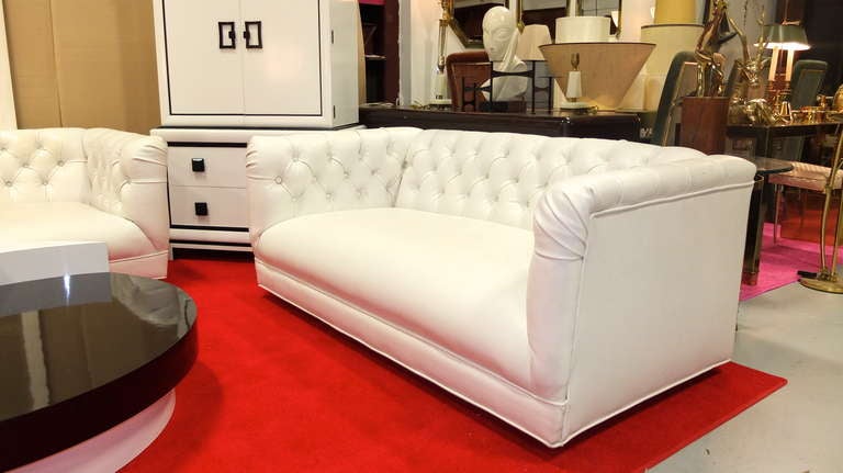 Vintage chesterfield loveseat sofa in white Naughahyde ordered through Charak Modern, Boston circa 1960.

Raised on four wooden cylindrical legs.

See our separate listing for the matching three seater sofa.

 