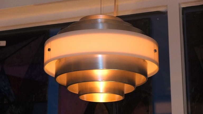 Generously proportioned pendant chandelier produced by Esperia, Italy, circa 1971/1972 and possibly designed by Angelo Brotto.  Fixture consists of six aluminum concentric rings and a white opaque acrylic central band, suspended by both a steel