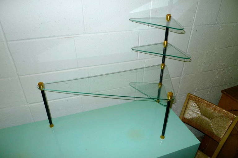 Charming isosceles triangular form four-tier glass, brass and enameled steel presentation etagere table by Dekora Nantes.
Lovely visual display for perfumes. jewelry, enameled picture frames or even bon bons and petits fours.
Tempered glass with old