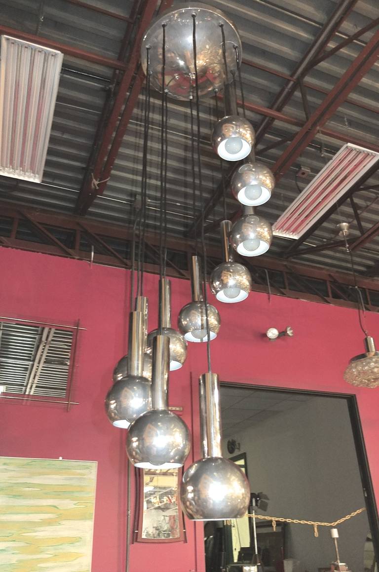 Original vintage 1960s suspension pendant with ten chrome balls cascading in spiral formation suspended by black cloth wire from a 14 inch chrome ceiling canopy.  Tubular chrome pipes slip on top of each ball giving the effect of a comets tail. The