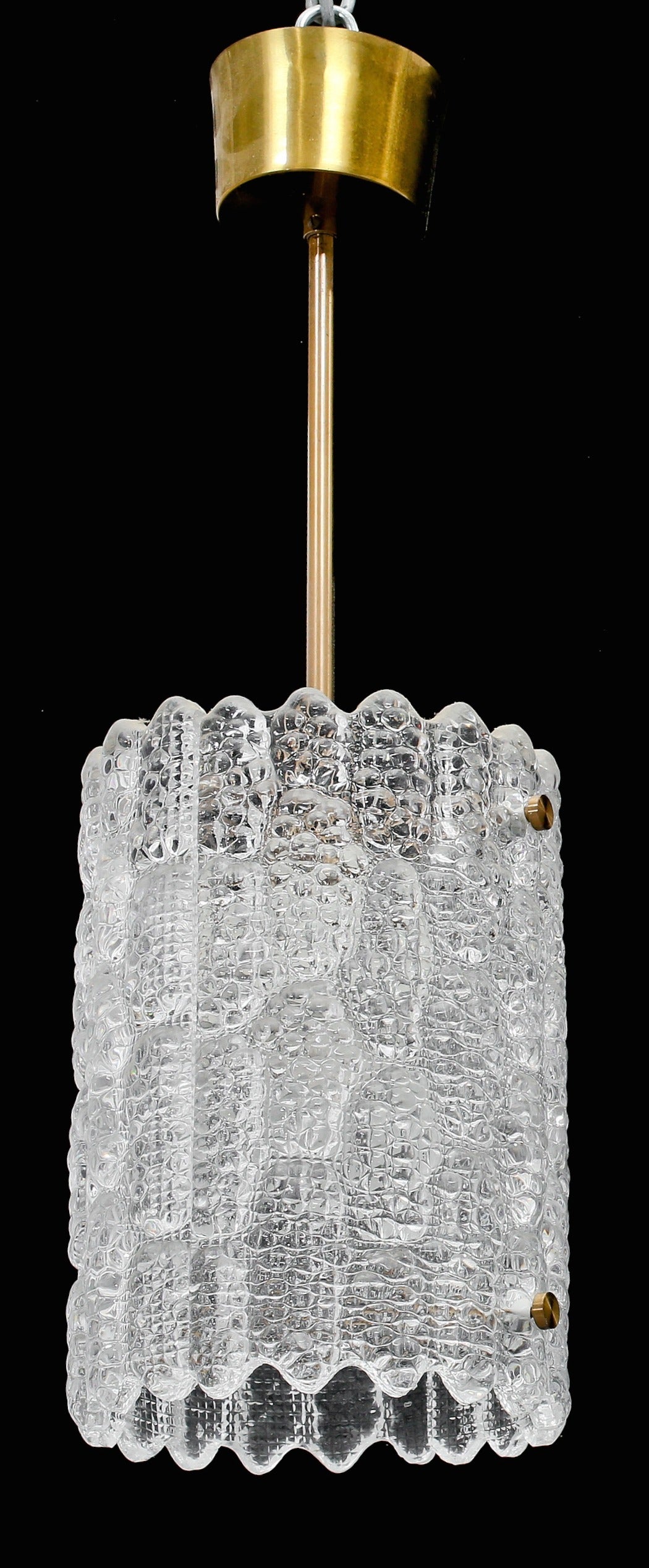 Pair of clear textured crystal lights in two halves held with brass hardware. 1950's.  By Carl Fagerlund for Orrefors, Sweden.  Total drop including canopy is 22 inches.  Glass is 10 inches high by 7 inches diameter. Each takes a single standard