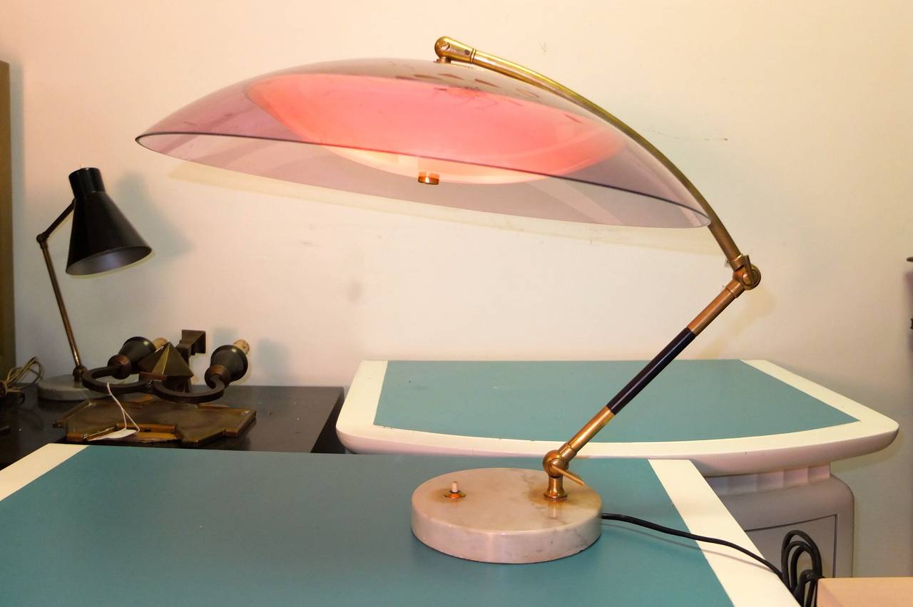 A 1950 Italian table lamp from Stilux Milano with Carrera marble base with switch and purple plexi dome reflector which can be playfully positioned from the articulating arm which has three adjustable joints.