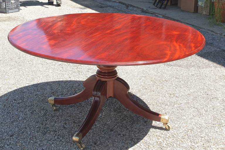 A fine quality Regency circular pedestal breakfast or dining table having beautifully figured grain mahogany top with a bull nose edge, turned bulbous column pedestal base with four moulded splay legs with carved knees, terminating in the original