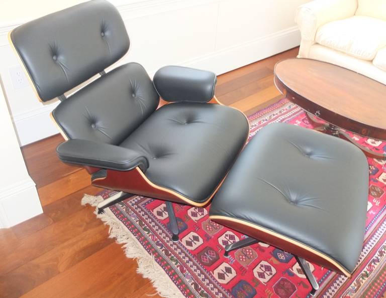 Herman Miller late production Eames lounge chair and ottoman in black leather and cherry.

Dimensions:

 Lounge chair:
H:32