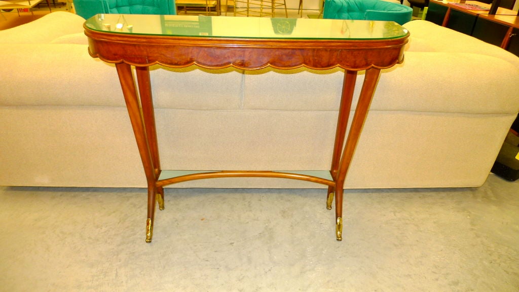 Elegant and petite console table with dainty feet , scalloped apron and brass sabots.