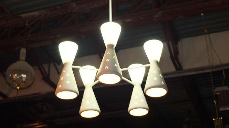 An iconic design of the Space Age this large white chandelier has five hourglass shaped double cones extending 9 inches around a circular hub and suspended by a long extendable pole (3 sections of 40 inches each).  The bottom cones are white