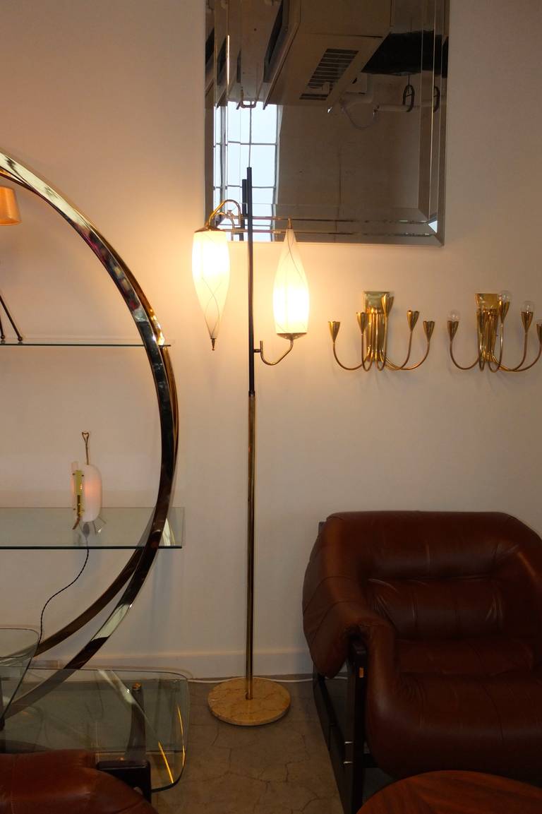 A tall, straight up Italian 1950's floor lamp having a round marble base, brass shaft the upper half of which is enameled black and double inverted cross-hatch embellished opaline glass spiral cylinders which suggest a reference to colorful silk